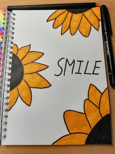 a spiral notebook with the words smile written on it and sunflowers painted on it