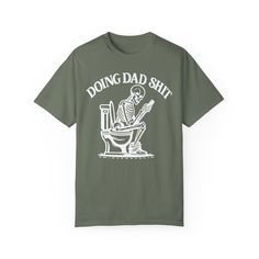 ✨💀 Introducing our "Doing Dad Shit" Skeleton T-Shirt! 💀✨ 🎉 Celebrate Father's Day with a humorous twist by gifting this custom tee featuring a skeleton on a toilet and the phrase, "Doing Dad Shit"! 🎉 💖 Crafted from 100% ring-spun cotton, this garment-dyed t-shirt offers unbeatable softness and comfort, perfect for everyday wear. 💖 😌 The soft-washed fabric adds an extra layer of coziness, making this tee an ideal choice for dads who appreciate both comfort and humor. 😌 💪 With double-needle stitching throughout, this tee is built to last, ensuring durability for all of dad's adventures. 💪 🔄 Say goodbye to bothersome side-seams – our shirt maintains its tubular shape for a sleek and flattering fit. 🔄 🎨 Show your appreciation with this fully customizable design featuring a playful Novelty Relaxed Fit T-shirt, Pre-shrunk, Novelty Screen Print Streetwear T-shirt, Novelty Screen Print T-shirt For Streetwear, Funny Screen Print T-shirt For Father's Day, Novelty Streetwear T-shirt With Screen Print, Funny Father's Day T-shirt With Screen Print, Funny Screen Print T-shirt In Ring-spun Cotton, Father's Day Band Merch T-shirt With Short Sleeves, Father's Day Band Merch T-shirt