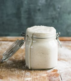 a jar filled with white powder sitting on top of a wooden table