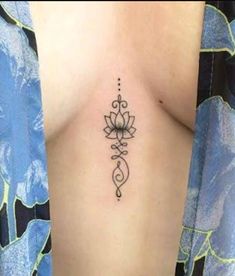 a woman with a tattoo on her stomach has a lotus design on the side of her body