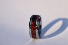 The Lava Rock Ring, Handmade Glowstone Ring, Red Opal Ruby Tungsten Inlay Engagement Ring, Glow in the Dark Wedding Band for Men and Women This is the Lava Rock Ring, primarily made with Ruby, Crimson Red and Lava Rock Opal on a black background with some red and glows red. The primary color of the Groom Wedding Band, Cosmic Ring, Dark Jewelry