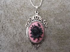 "For sale are beautiful flawless (black rose with a single bud on a pink background) cameo pendant necklaces They are offered at a reasonable price, make perfect gifts, and are wonderful quality The cameo is set in a gorgeous ornate tibetan silver setting, and the chain is 22\" .925 silver plated 1.2mm snake chain, with a lobster claw clasp I make several varieties, colors, styles and matching sets I will be glad to do special requests or matching pendant, cuff bracelet and/or brooch if you don' Rose-colored Gothic Jewelry For Gift, Gothic Rose Jewelry For Gift, Gothic Rose Colored Jewelry For Gift, Gothic Rose-colored Jewelry For Gifts, Pink Cameo Necklace For Gifts, Black Round Cameo Jewelry, Pink Rose Pendant Jewelry, Black Cameo Jewelry For Gifts, Black Cameo Jewelry As A Gift