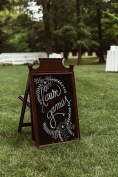 a chalkboard sign sitting on top of a lush green field