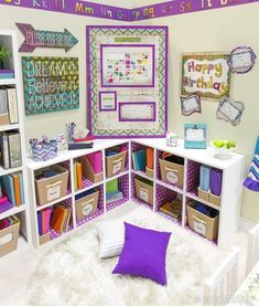 a room filled with lots of colorful books and boxes on the wall next to a bed