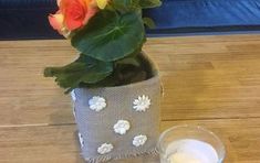 a vase filled with flowers sitting on top of a wooden table next to a candle