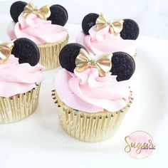 four cupcakes decorated with pink frosting and black minnie mouse ears on top