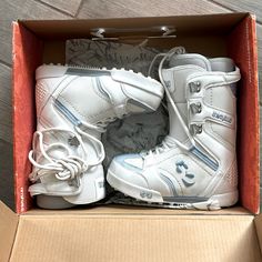 two pairs of white shoes in a box