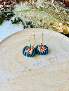 These fun pumpkin hoop earrings have been handmade with polymer clay. All floral detail work is completely done by hand giving each pair a unique look! These are truly one of a kind! You can choose from gold plated stainless steel, antiqued brass or regular stainless steel hoops. All hoops are nickel free, making these great for sensitive ears. The hoops are about 1 inch in diameter. The clay pumpkins are about 1 inch in width. The total length of the earrings is about 1.5 inches. These earrings are super lightweight and so comfortable to wear! Very cute for fall and Halloween! Be sure to check out our shop for more colors! www.etsy.com/shop/theglassbird Also come like our facebook page to receive updates on new items, coupon codes and future giveaways! https://www.facebook.com/TheGlassBir Handmade Polymer Clay Flower Earrings In Gold, Gold Whimsical Polymer Clay Earrings, Whimsical Gold Polymer Clay Earrings, Handmade Gold Polymer Clay Flower Earrings, Whimsical Handmade Clay Earrings, Handmade Gold Flower Earrings In Polymer Clay, Handmade Clay Flower Jewelry, Hoop Earrings In Polymer Clay For Gift, Handmade Polymer Clay Dangle Hoop Earrings