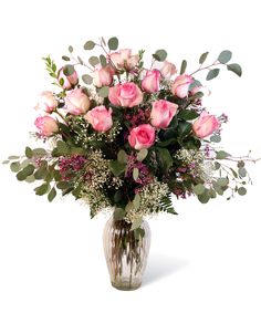 a vase filled with pink roses and greenery