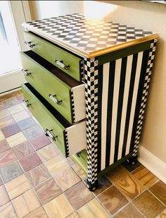 a green and white dresser with checkered drawers on it's sides in a room