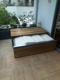 a wooden bench sitting on top of a hard wood floor next to a planter