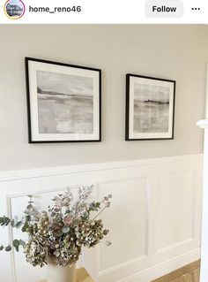 two framed pictures hang on the wall above a vase with flowers