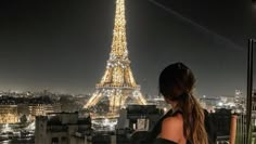 a woman looking at the eiffel tower in paris