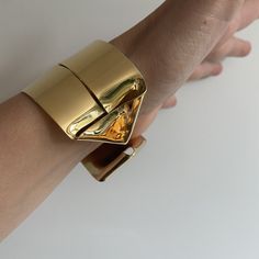 A lighter cuff on the repertoire. I have created this piece out of a single sheet of metal. It is completely formed and can be worn showing the ends on the front or the wide strip on the front. ~1.5 wide   ~fabricated out of a single brass sheet and finished in 14k nickel free gold plating  Bracelet is light and can be adjusted to fit the wrist. Slip on gently due to the ends but adjust by softly squeezing to fit around your wrist a little less loosley. Modern Gold Open Cuff Jewelry, Modern Wide Band Cuff Bracelet With Polished Finish, Modern Yellow Gold Wide Band Bracelet, Unique Cuff Bracelet For Formal Occasions, Modern Metal Cuff Bangle, Gold Polished Cuff Bracelet, Gold Polished Open Cuff Bracelet, Gold Open Cuff Bracelets For Party, Elegant Open Cuff Metal Bracelet