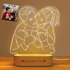 an illuminated lamp with a couple hugging each other