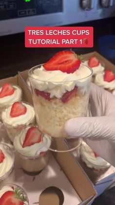 a person in white gloves holding up a dessert cup with strawberries on top and the words, tres leches cups tutorial part 2