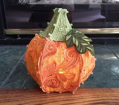 an orange pumpkin sitting on top of a wooden table