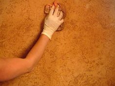 a person in white gloves is on the floor with their hand wrapped around an object