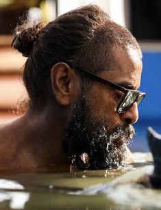 a man with a beard and sunglasses in the water