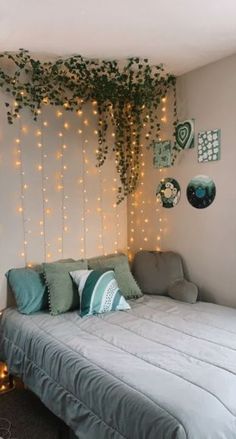 a bed sitting in a bedroom next to a wall with lights on it and a plant growing over the headboard