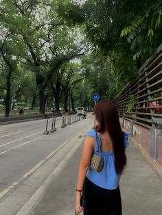 a woman is walking down the street with her hand in her pocket and looking back