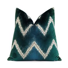 a green and white pillow with chevroned lines on the front, sitting on a white background