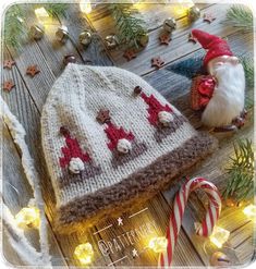 a knitted hat with santa clause on it next to candy canes and christmas decorations