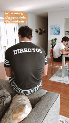 a man sitting on top of a couch next to a table