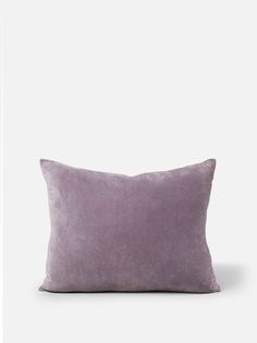 a purple pillow sitting on top of a white wall