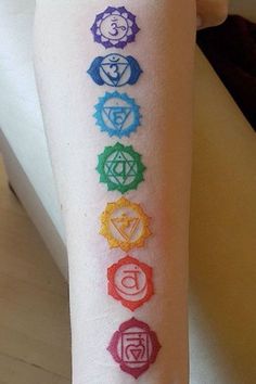 a woman's arm with seven chakras on it