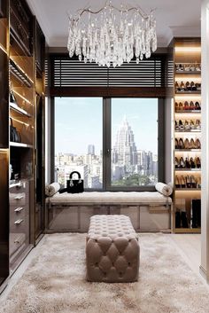 a walk in closet with chandelier and shoes on the shelves next to it