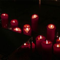 many red candles are lit in the dark