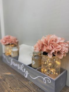 two mason jars filled with flowers sitting on top of a wooden shelf