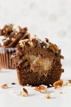 there is a chocolate cupcake with nuts on the top and one half cut in half