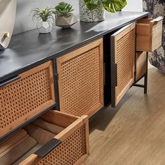 the sideboard is made out of wood and has two planters on it