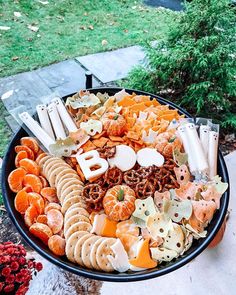 a platter filled with cheese, crackers and oranges on top of a table