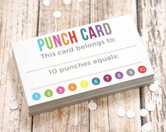 a punch card sitting on top of a wooden table next to some confetti