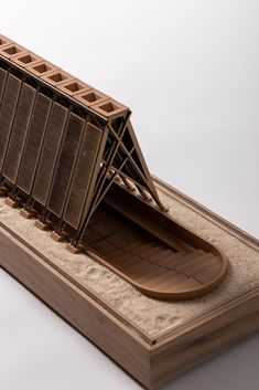 a wooden model of a boat on sand in the shape of a bridge and ramp