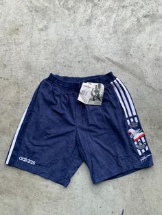 Vintage Adidas Deadstock Blue and White Sprinter Short Size M in great condition without any holes. The shorts are stretchy. Size: M (see measurements) Material: 20% Cotton, 80% Polyester Measurements: - Total length: 47 cm(18.5") - Waist: 36 cm(14.1") - Waist stretched: 50cm(19.6") NOTE: Due to the age, clothing/items can shrink or it may be that the sizing from that time the item was made in, is not the same as the sizing in modern clothing and current sizes. Make sure you check our measuremen Affordable Adidas Three Stripes Shorts, Summer Sports Shorts With Three Stripes, Summer Sportswear Shorts With Three Stripes, Sports Shorts With Three Stripes, Three Stripes Sports Shorts, Casual Sports Shorts With Three Stripes, Three Stripes Shorts For Sports Events, Casual Shorts With Three Stripes For Sports Events, Sports Athletic Shorts With Three Stripes