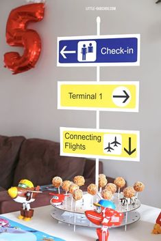 a table topped with donuts covered in frosting next to a sign that says check - in