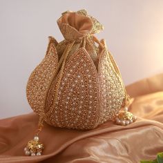 Discover the Elegant Lotus Potli Bag by THE TAN CLAN Elevate Your Style with Our Unique Embroidered Indian Bridal Potli Bag by THE TAN CLAN Transform your accessory collection with the Elegant Lotus Potli Bag--a stunning fusion of traditional craftsmanship and modern design. This exquisite embroidered potli bag is perfect for weddings, engagements, bridesmaid gifts and anniversary gifts. With its intricate detailing and luxurious finish, this bag is a must-have for anyone looking to add a touch Elegant Gold Bridal Accessories With Pallu, Gold Bridal Accessories For Reception And Festivals, Gold Embroidered Pouch For Celebration, Gold Embroidered Celebration Pouch, Gold Bridal Accessories For Festivals, Gold Potli Bag With Intricate Embroidery For Festive Occasions, Festive Gold Potli Bag With Intricate Embroidery, Festive Gold Potli Bag For Reception, Gold Embroidered Potli Bag For Celebration