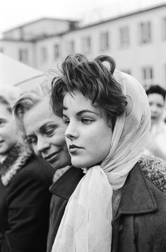 black and white photograph of women with scarves on their heads looking off to the side