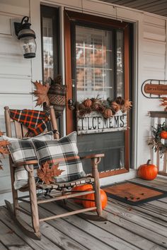 a rocking chair on a porch with fall decorations