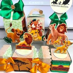 the lion king party favors are on display in front of a box with green ribbon