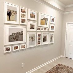 a wall with many pictures on it and a rug in front of the door that leads to another room