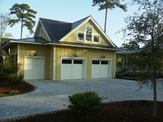 a yellow house with two garages in the driveway