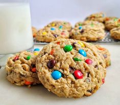 cookies with m & m and chocolate chips next to a glass of milk