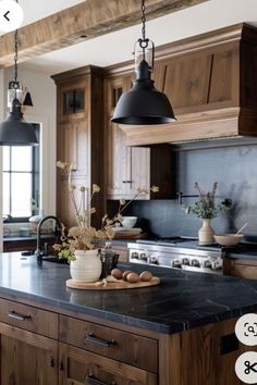 a large kitchen with wooden cabinets and black counter tops, along with an island in the middle