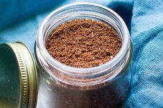 a jar filled with brown stuff sitting on top of a blue cloth