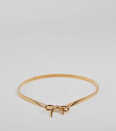 a gold bracelet with a bow on the end and a small knot at the top